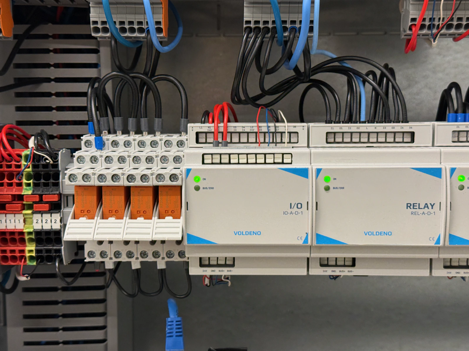 Voldeno 物件の分電盤: DINレール上の I/O と RELAY、ソケットに収めたオレンジ色の外部リレー